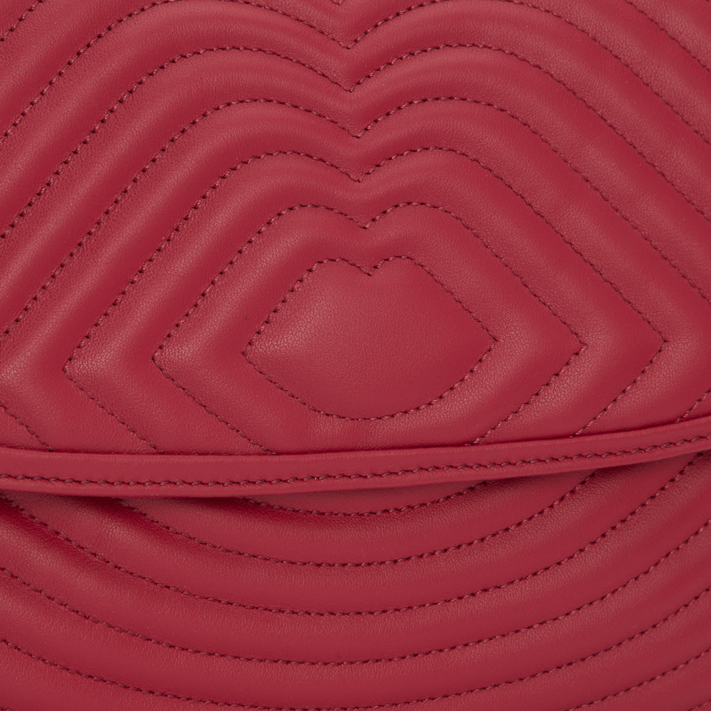 Close-up of a quilted, crimson-red leather handbag.