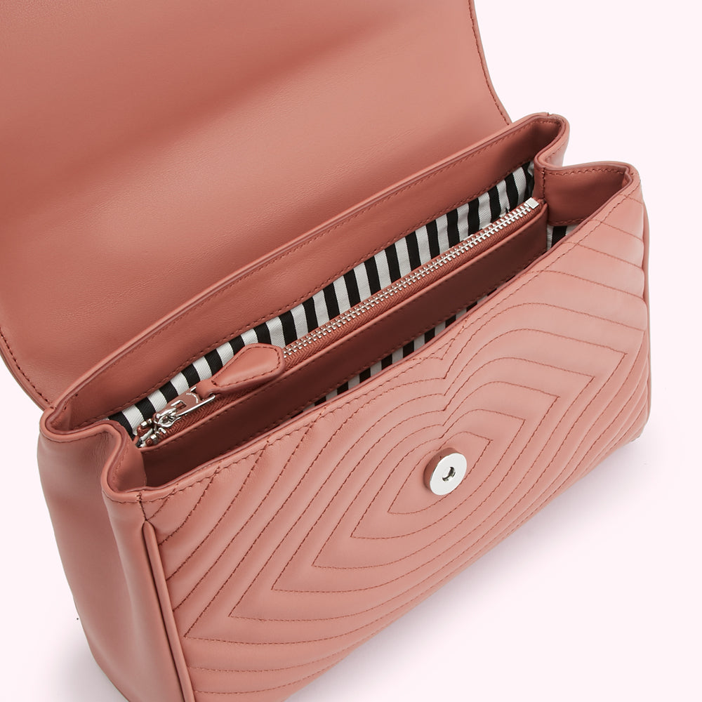 Dusty rose quilted leather handbag open to reveal black and white striped interior lining and a silver zipper.