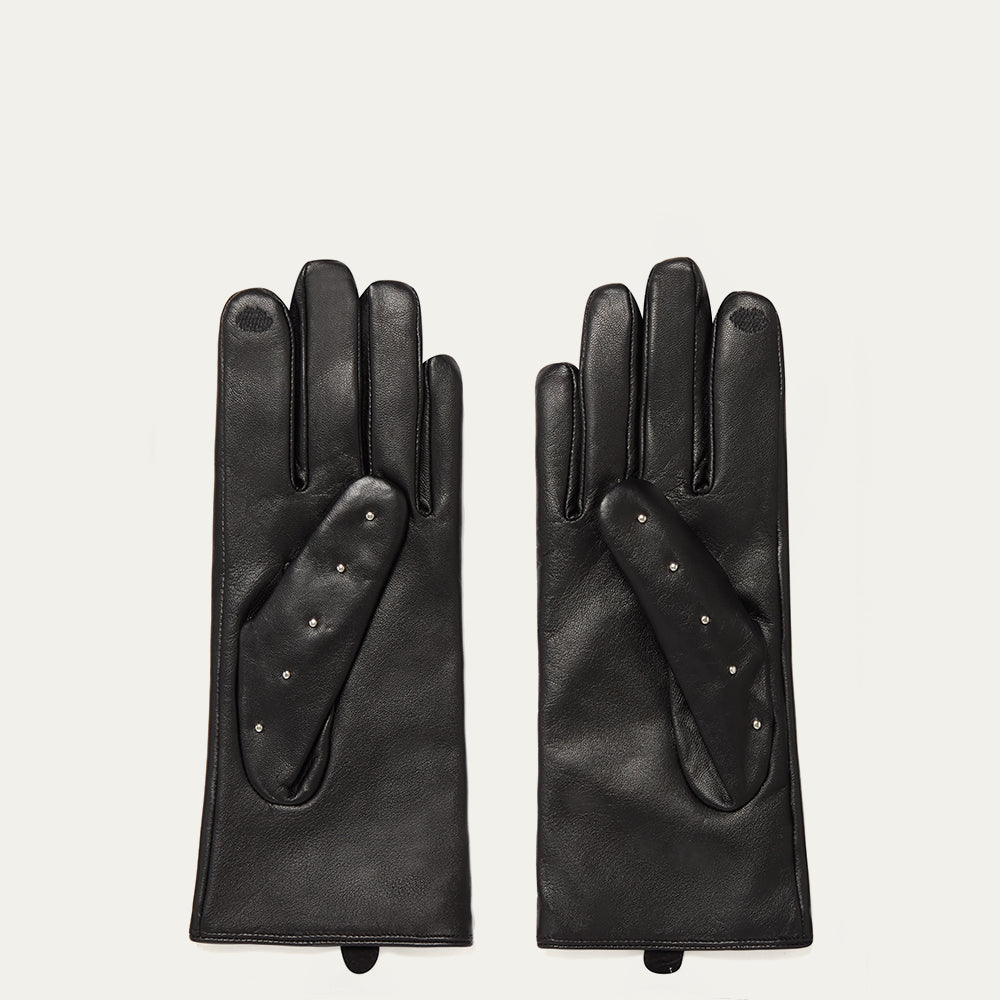 Pair of black leather gloves on a light gray background