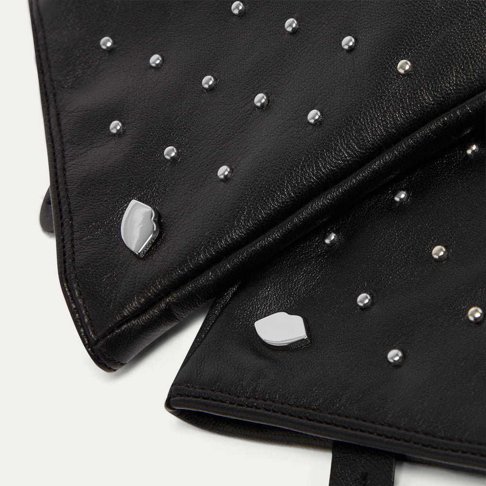 Close-up image of black leather gloves with silver studs on a white background