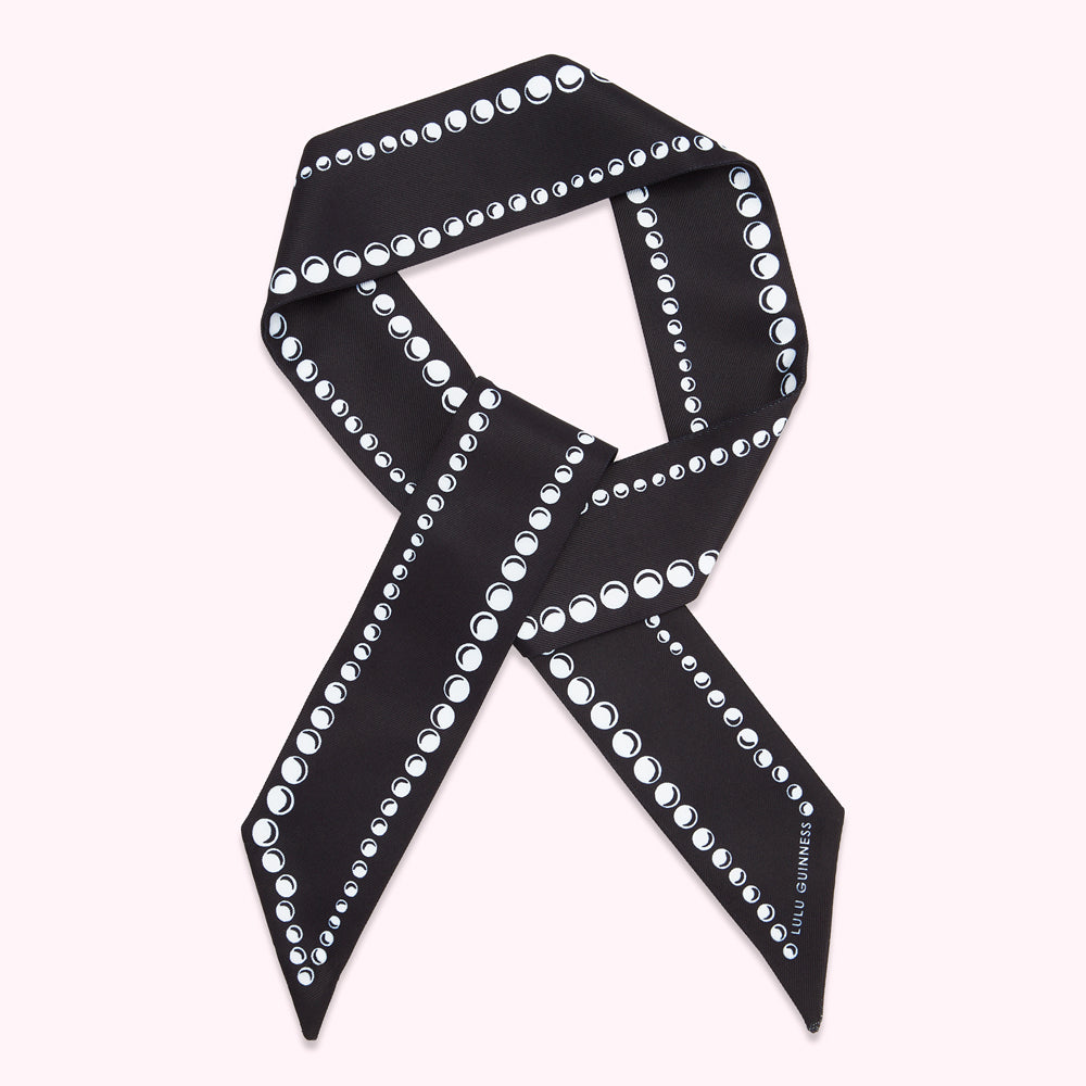 Black silk scarf with a white pearl pattern.