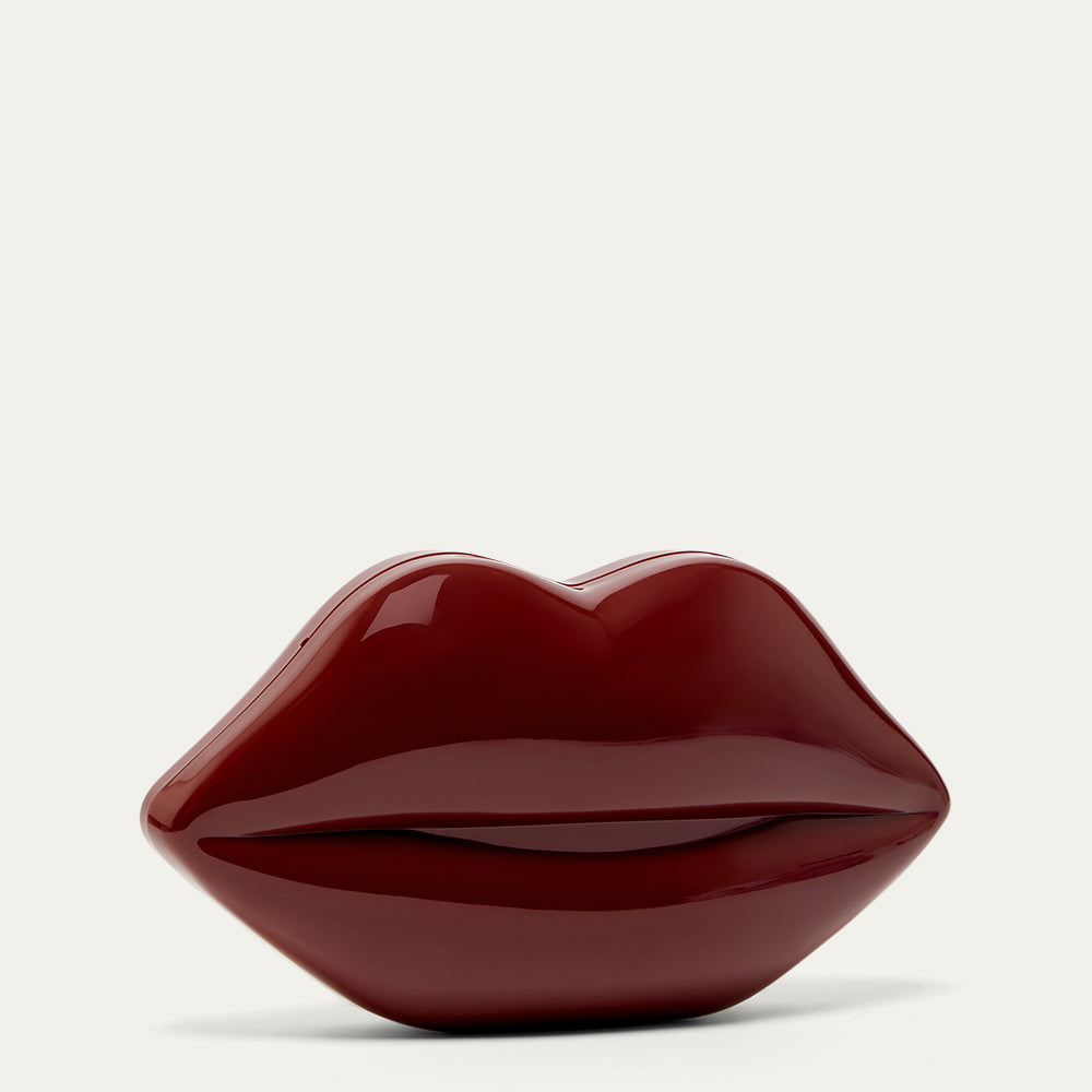 Glossy burgundy red lip-shaped clutch bag on a light gray background