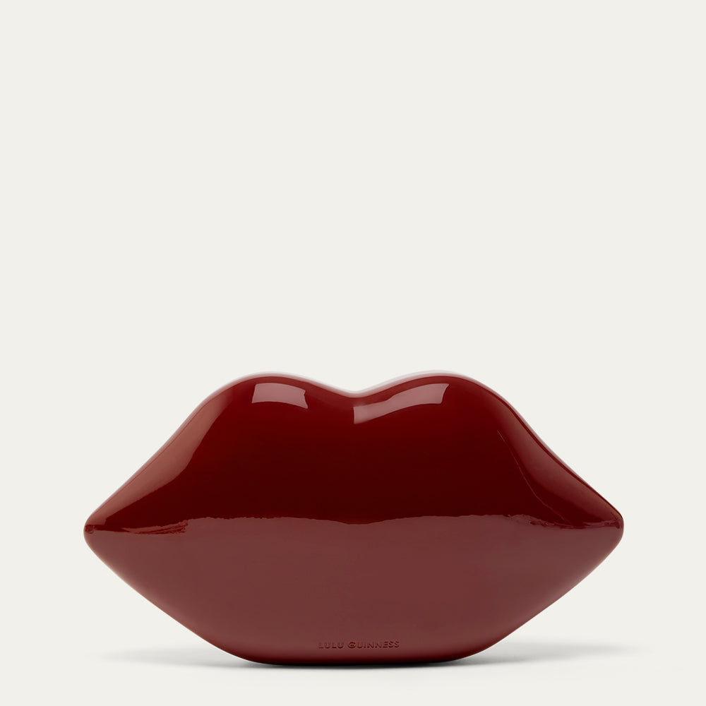 Burgundy red lip-shaped clutch bag on a light gray background