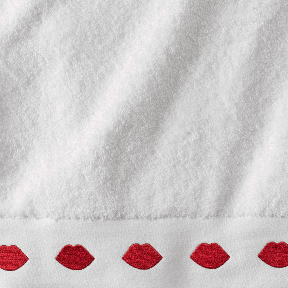 Close-up image of a white bath towel with a row of red lips on the edge