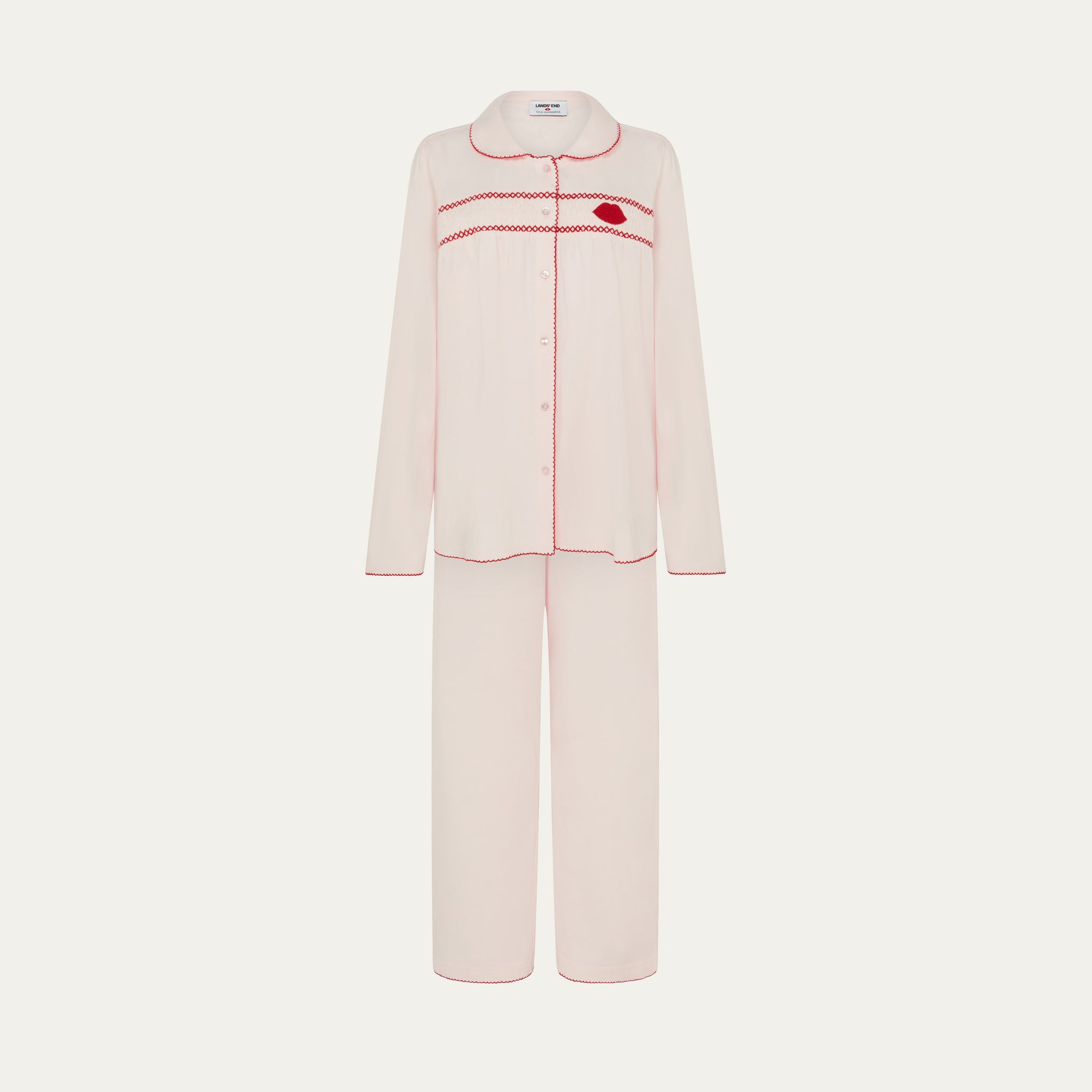 Pink pajama set with red stitching on a white background