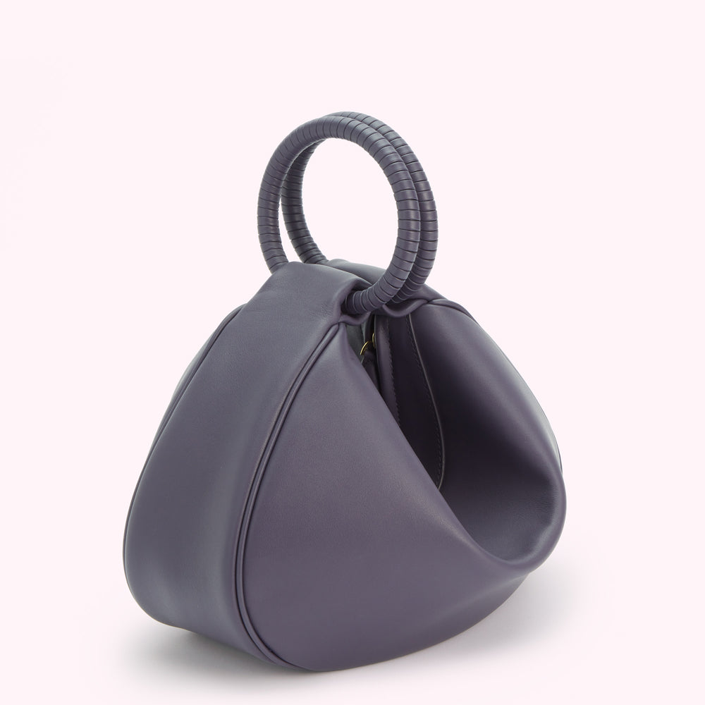 A purple leather handbag with a double ring handle.
