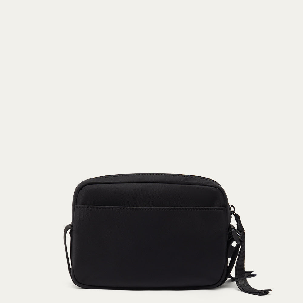Black crossbody bag on a light grey background