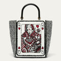 A structured white boucle tote bag with a red and black illustrated queen playing card design on front and back with black vertical  stripes on the side panels and a glossy black top handle.