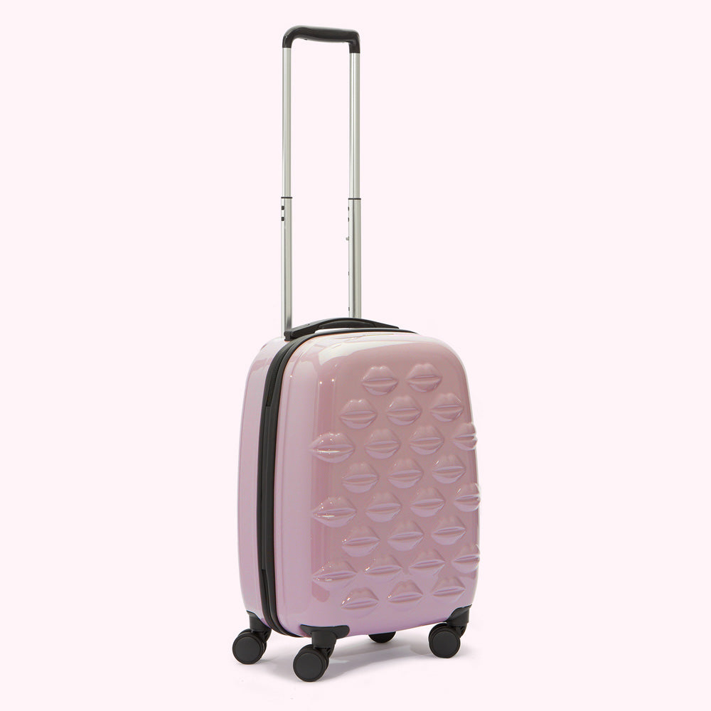 Pink carry-on suitcase decorated with lip prints.