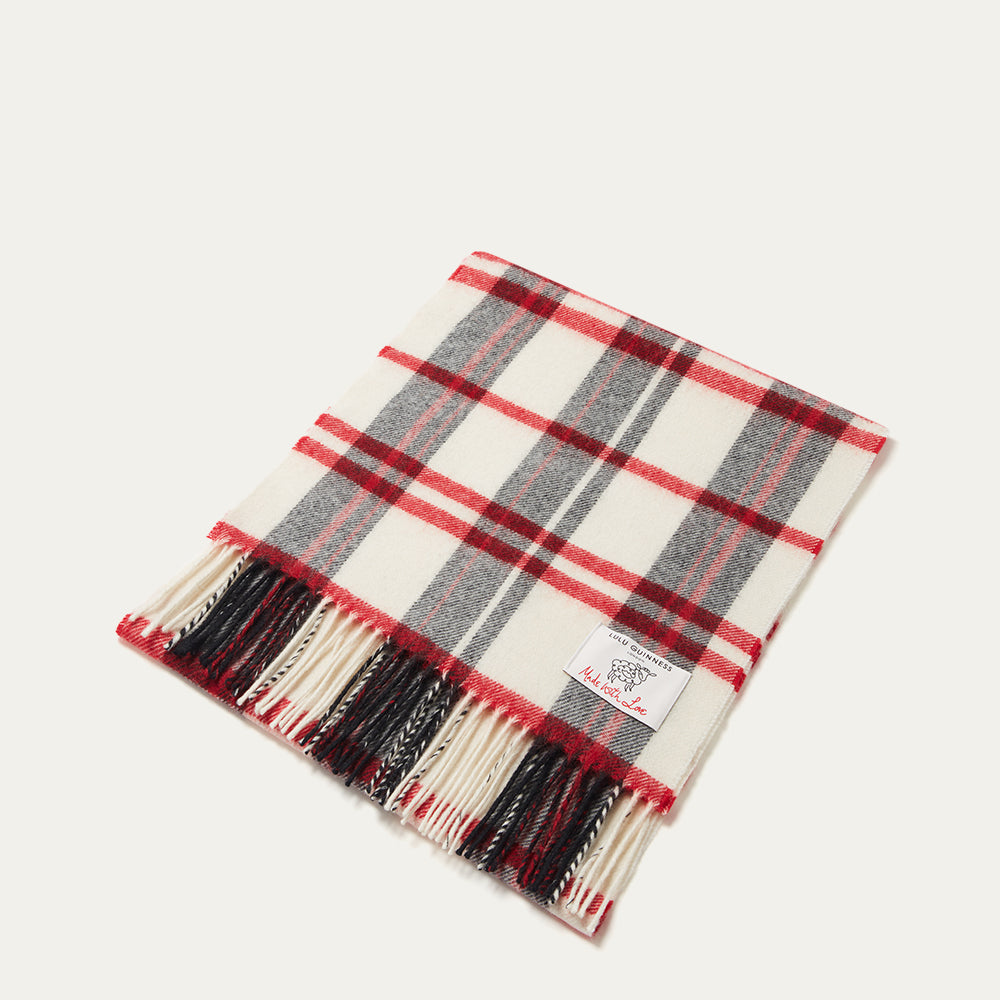 Plaid scarf with red, black, and white pattern on a beige background