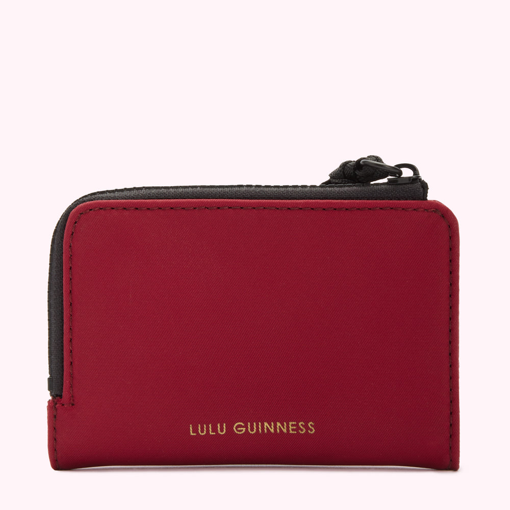 Red Lulu Guinness zip-around wallet with black zipper.
