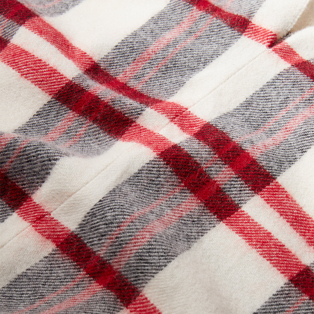Close-up of a red, gray, and white plaid poncho