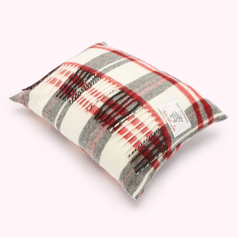 Rectangular cream cushion with red, grey and black plaid or tartan pattern and fringed edges. The Lulu Guinness logo is visible.
