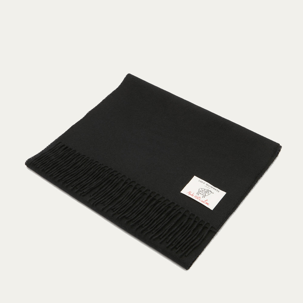 Black Lulu Guinness scarf with fringe and a small white label.

