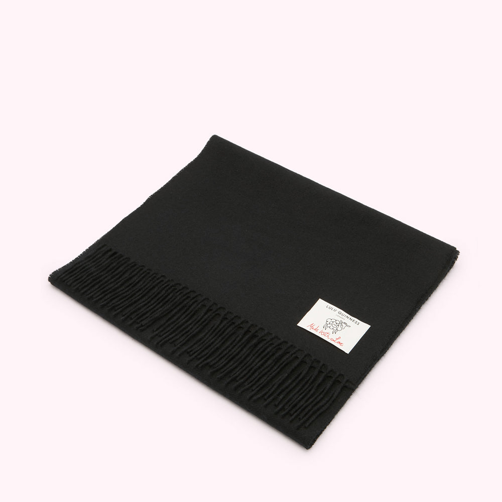 Black Lulu Guinness scarf with fringe and a small white label.
