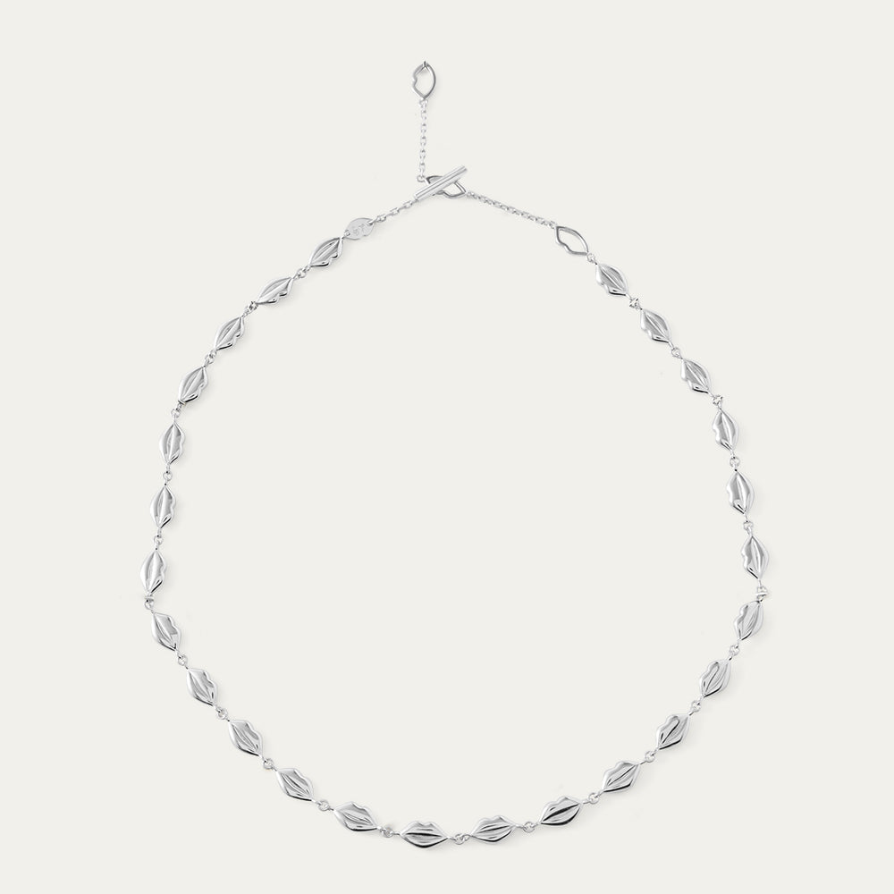 Silver lip chain necklace on a light gray background