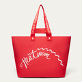 A red tote bag with white script text reading 'Heatwave' across the front and red shoulder straps with 'LULU GUINNESS' in white, shown on a light gray background.