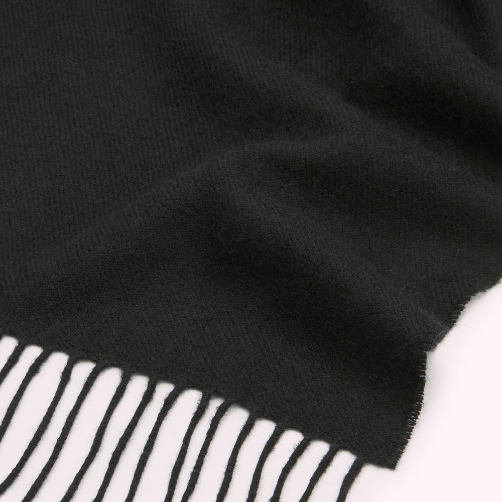 Close-up of a black fringed scarf.
