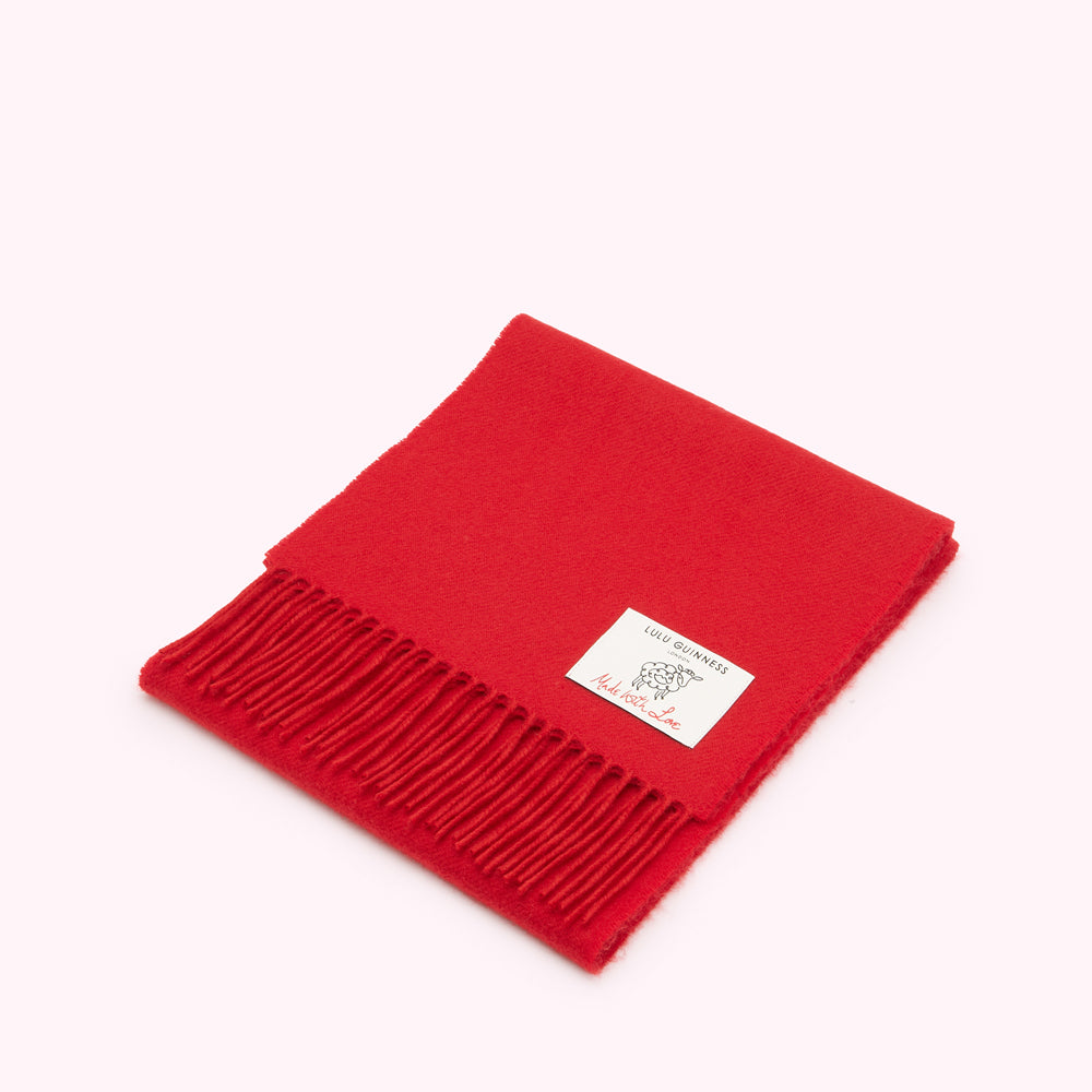 Red Lulu Guinness wool scarf with a fringe and a small label.
