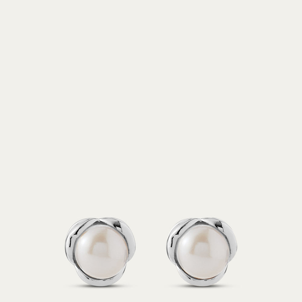 Pair of silver earrings with pearls on a light gray background