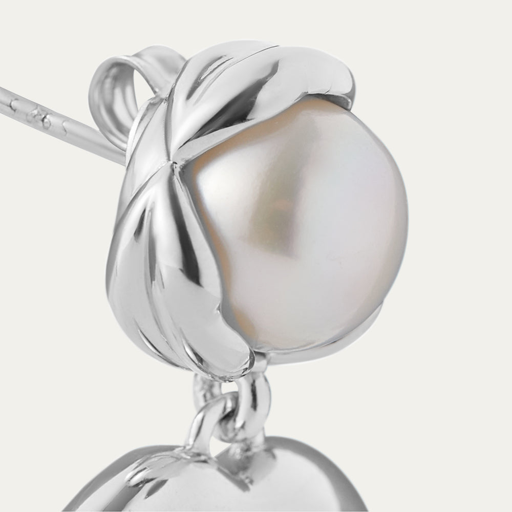 Silver earring with a pearl-like bead on a white background