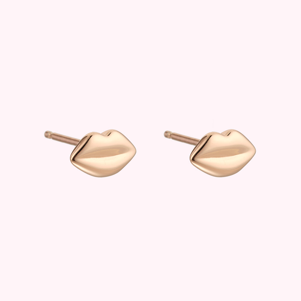 Rose gold lip-shaped stud earrings against a white background.
