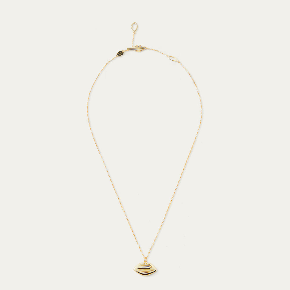 Gold necklace with a lip-shaped pendant on a white background