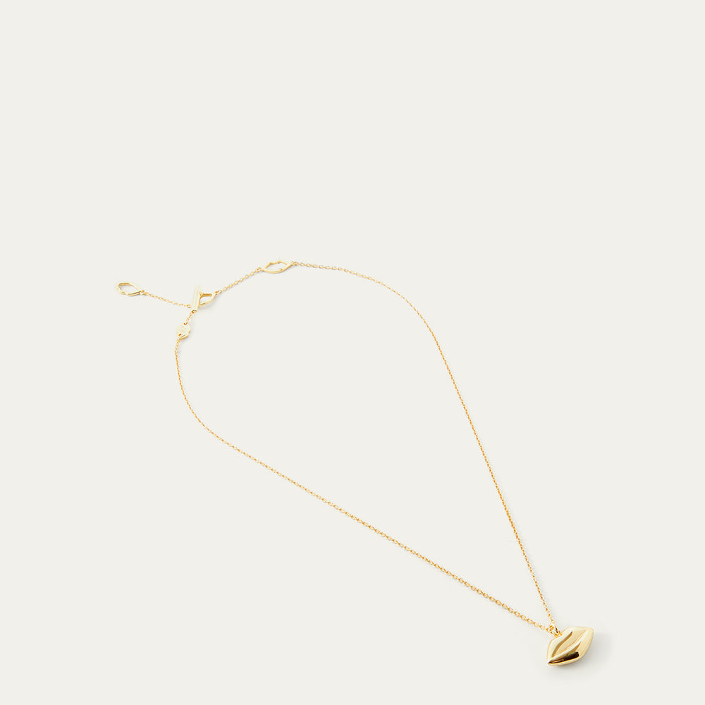 Gold necklace with a lip-shaped pendant on a white background