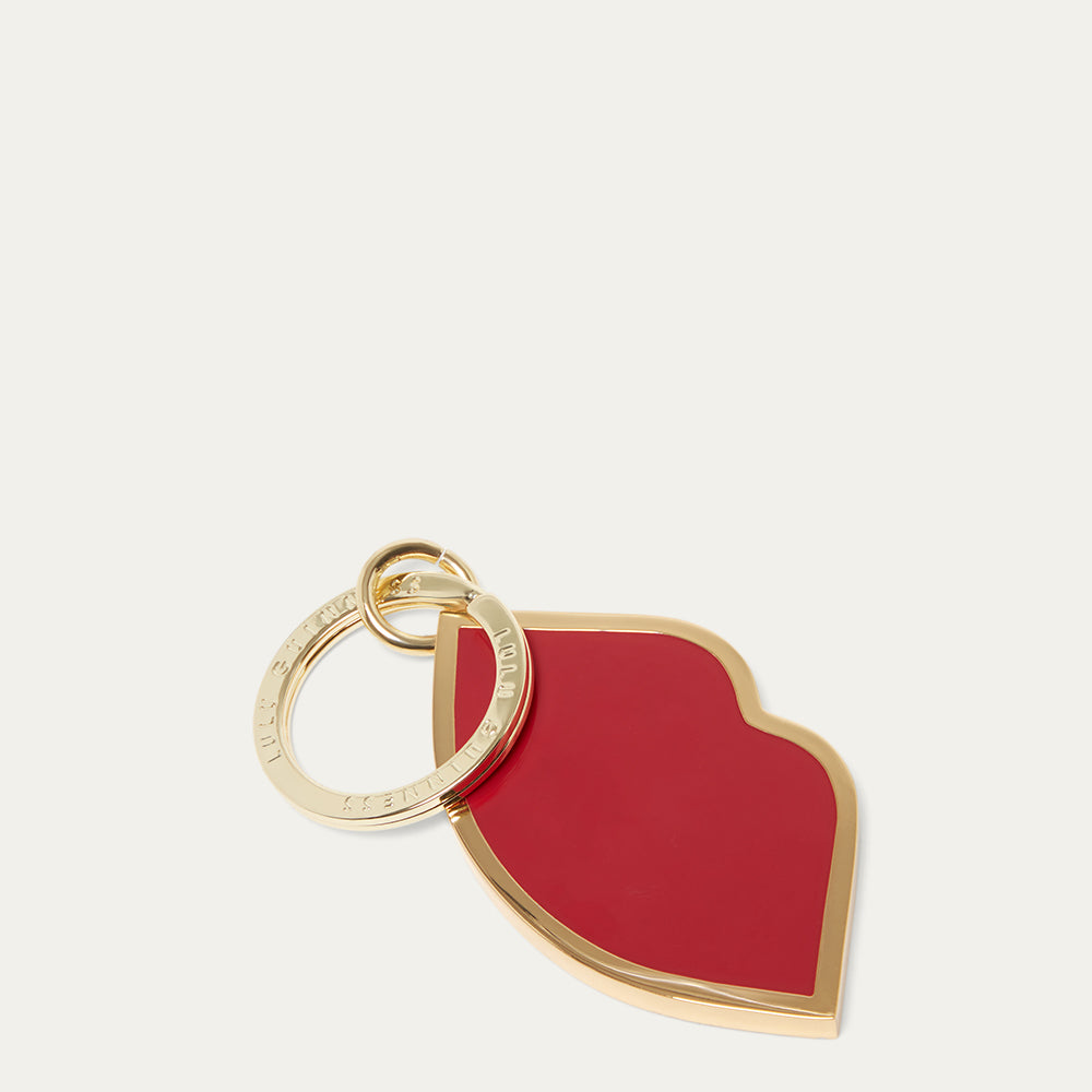 Red lip-shaped keychain with gold ring on a white background