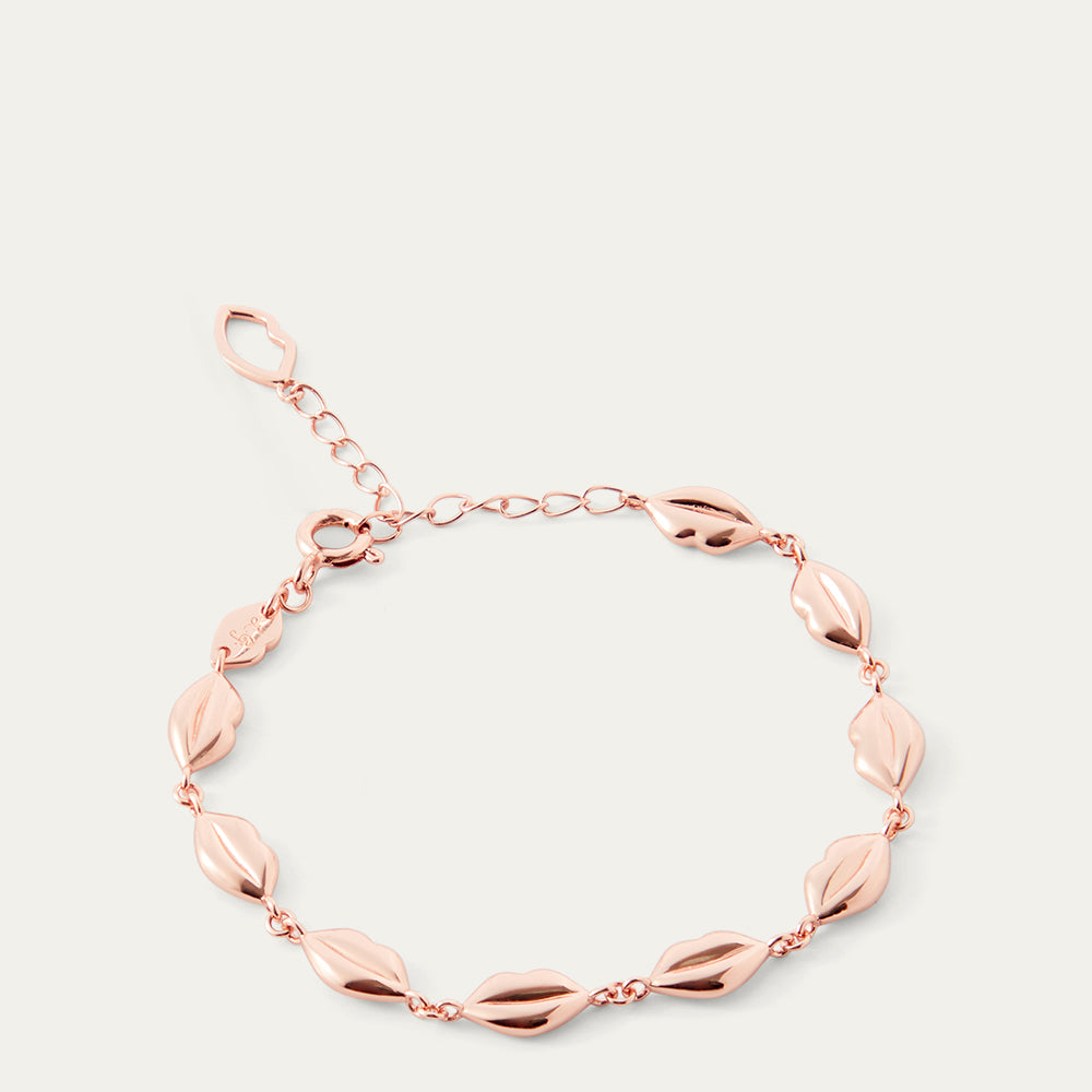 Rose gold lip chain bracelet on a light gray background