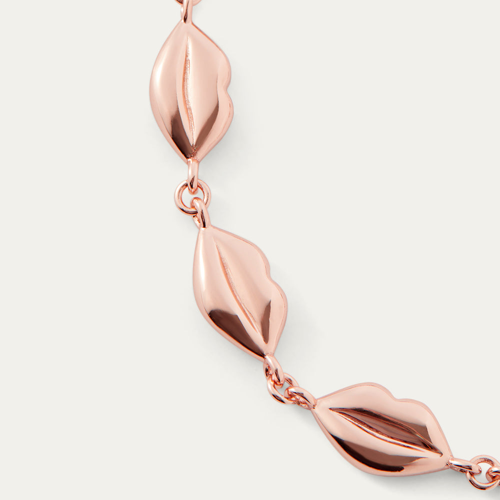 Rose gold lip chain bracelet on a light gray background