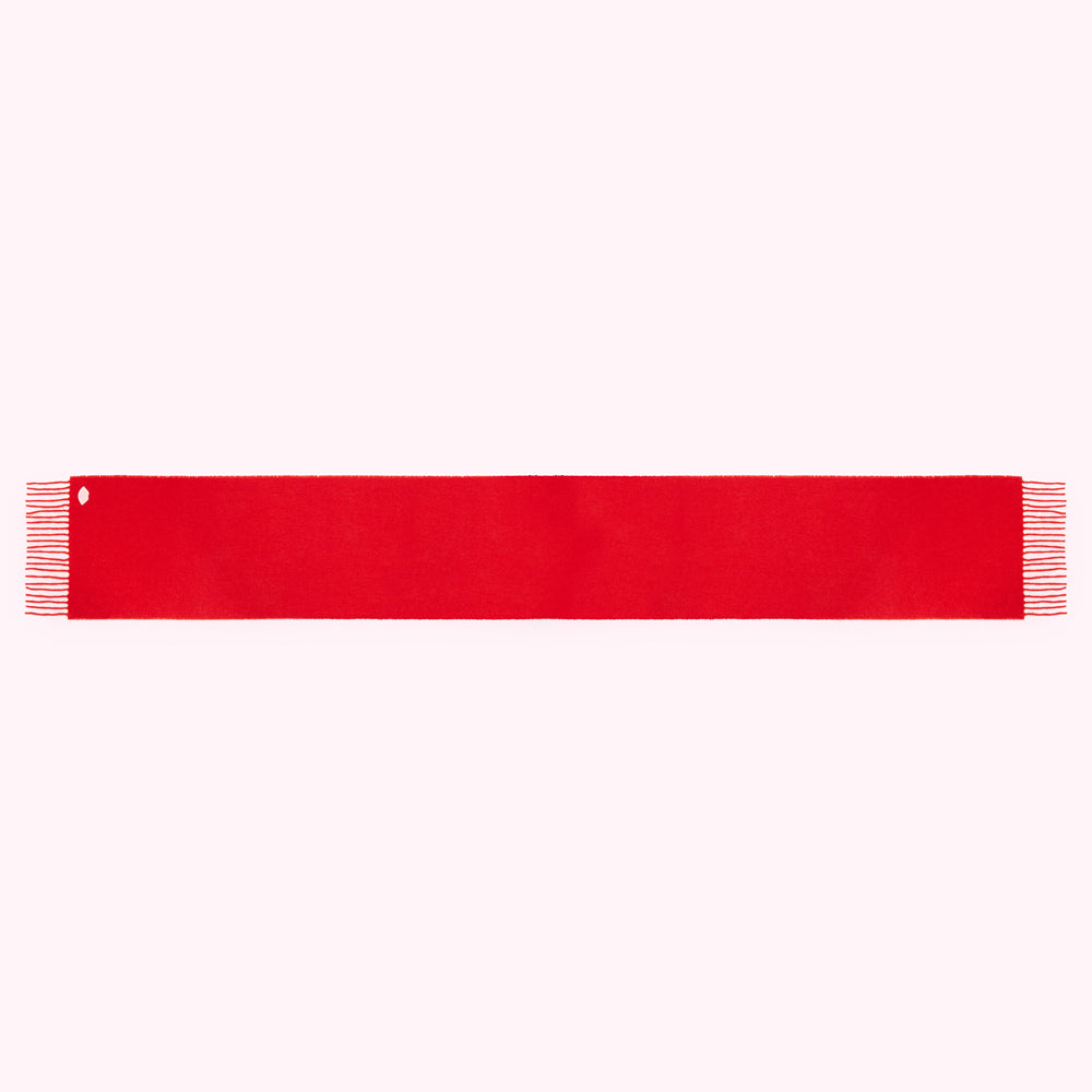 A long, solid red scarf with frayed ends and a small hole near one end, isolated on a white background.
