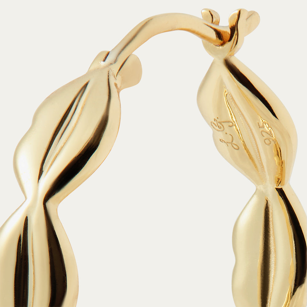 Gold hoop earrings on a light gray background