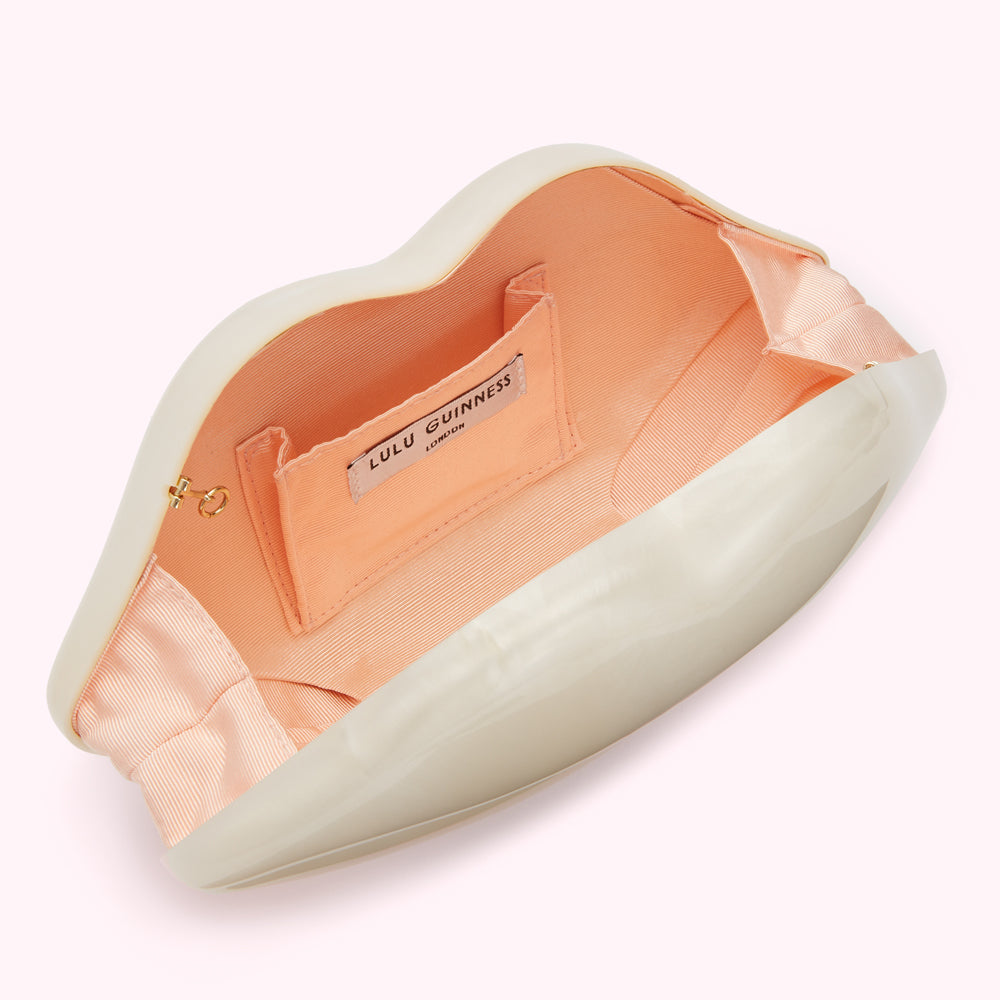 Open off-white Lulu Guinness lip-shaped clutch with peach interior.
