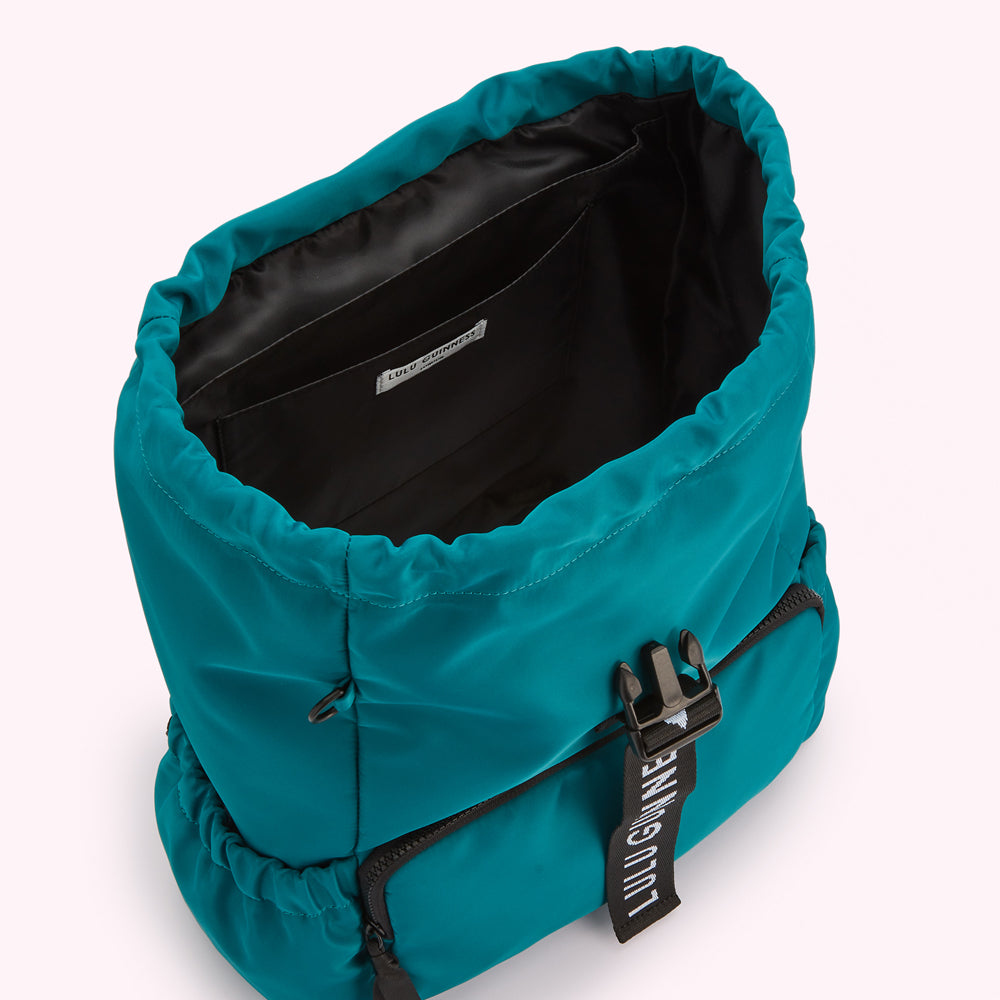 Teal Lulu Guinness backpack open to reveal the black interior and a small pocket.
