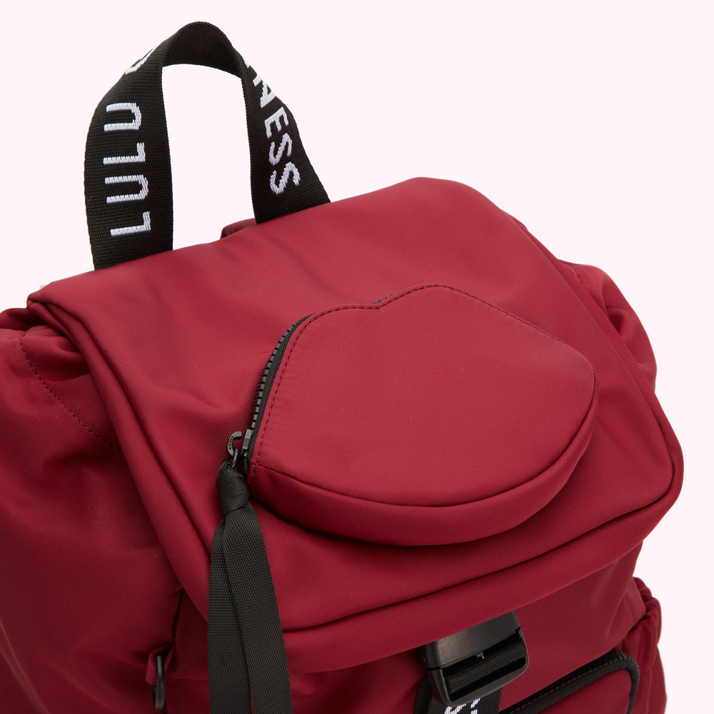 Close-up of a burgundy Lululemon backpack with a heart-shaped zipper pocket.