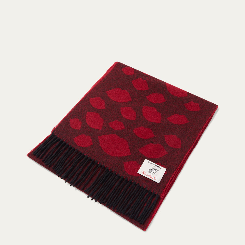 Red wool scarf with lip pattern folded on a white background