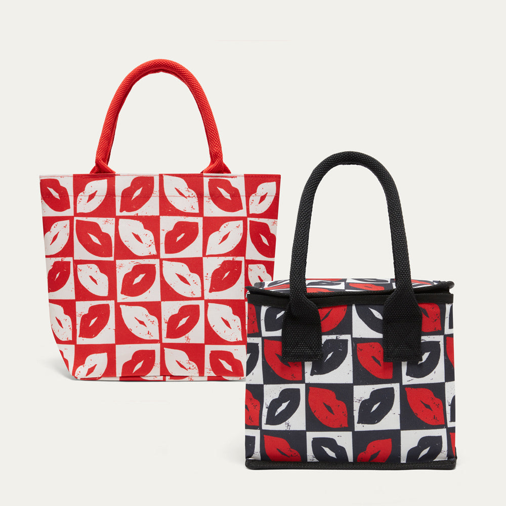 Two tote bags with a repeating lip print on a light gray background. The left bag has red handles and a red-and-white checkered pattern with red and white lips.