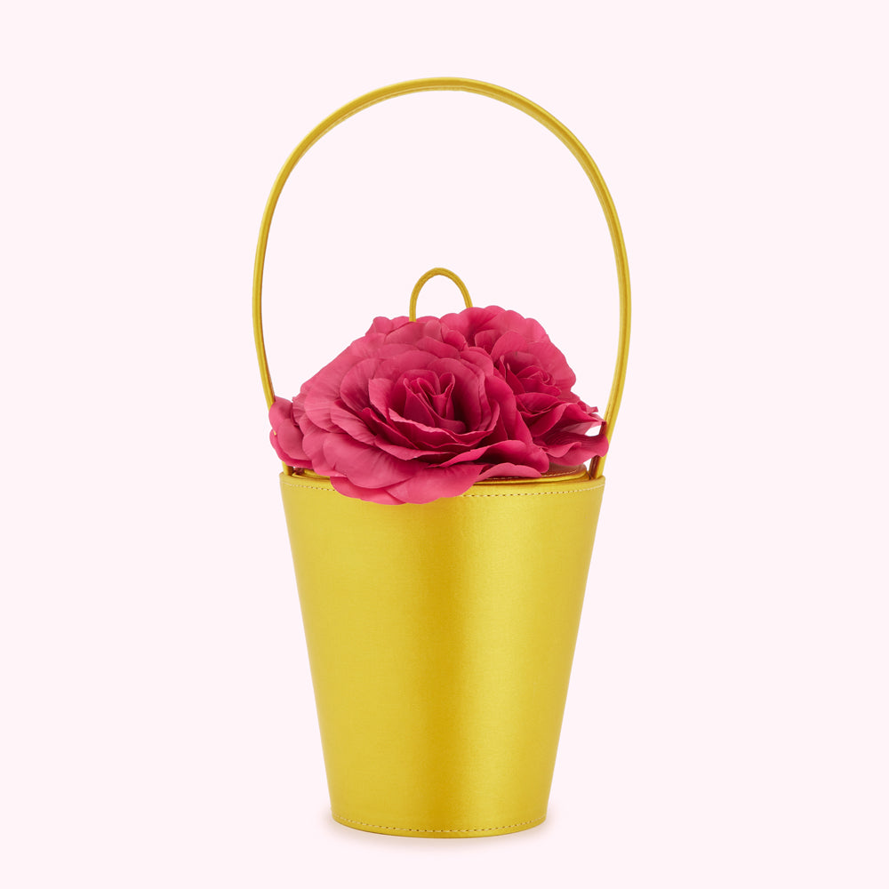 A chartreuse yellow satin bucket bag with a top handle, adorned with a cluster of fuchsia roses.