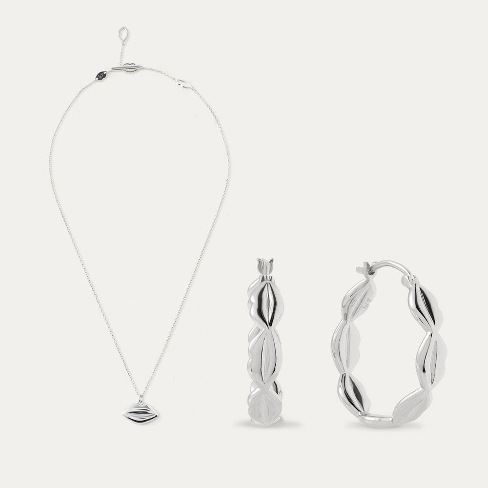 Silver necklace, pendant, and hoop earrings on a white background