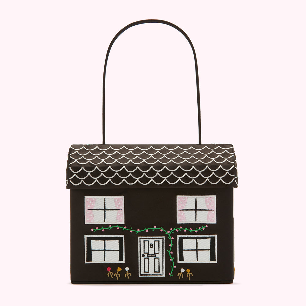 Black house-shaped handbag with embroidered details.