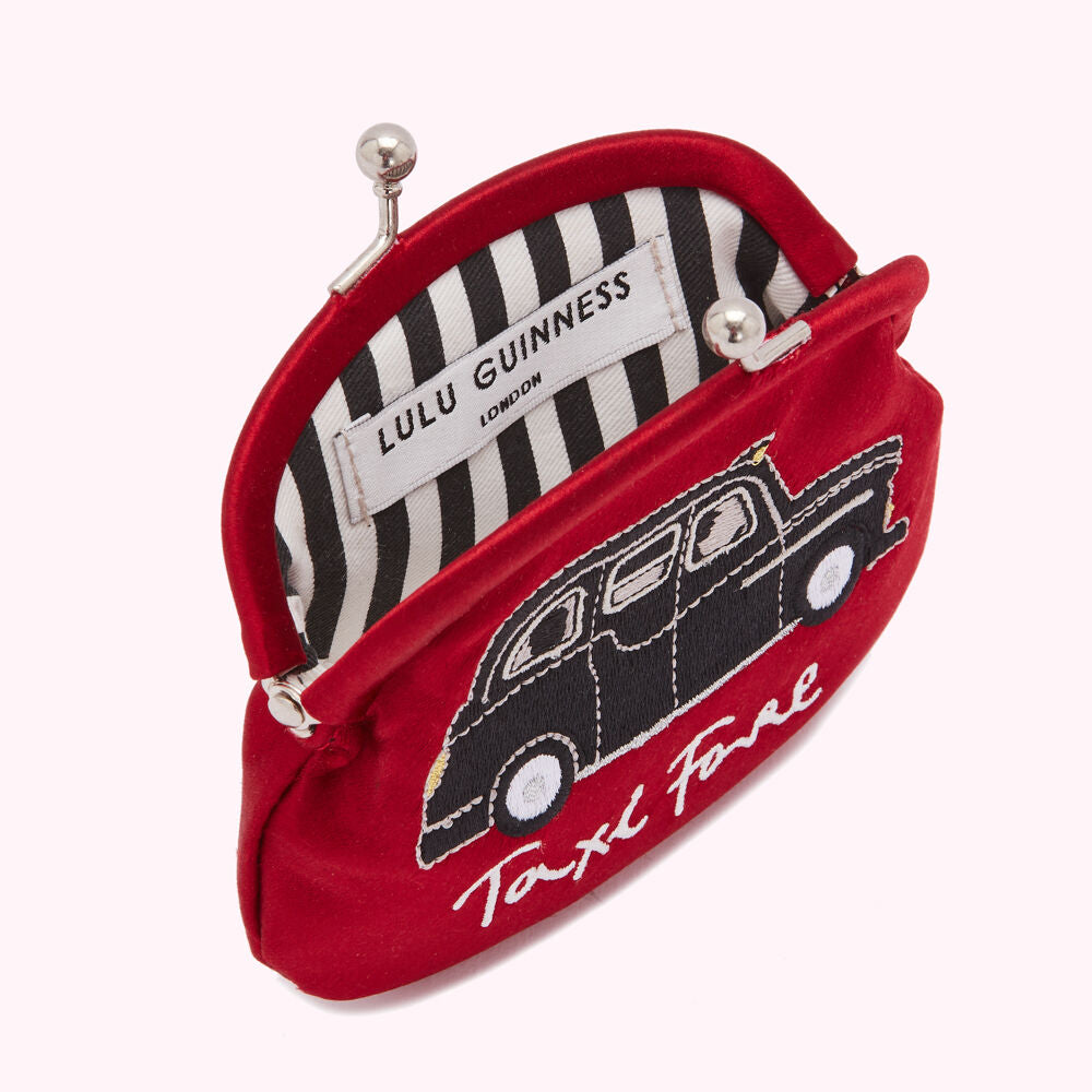 Red Lulu Guinness purse with black embroidered taxi design and "Taxi Fare" text; the purse's interior lining is black and white striped.