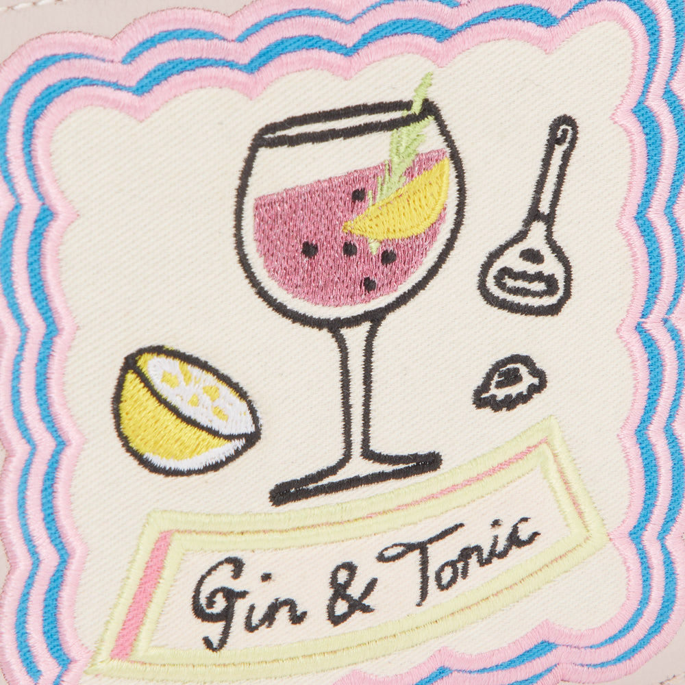 Embroidered patch on a cream background with pink, light blue and yellow stitching depicting a gin and tonic drink with a lemon wedge and cocktail spoon, text reads "Gin & Tonic".