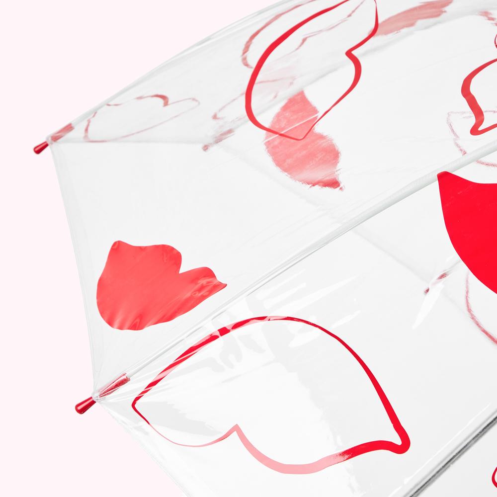 Close-up of a clear umbrella with red heart-shaped designs.
