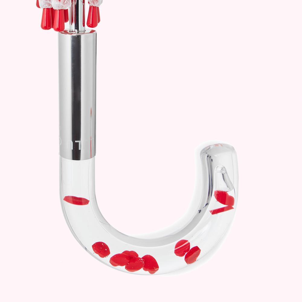 Close-up of a clear umbrella handle containing small red hearts.