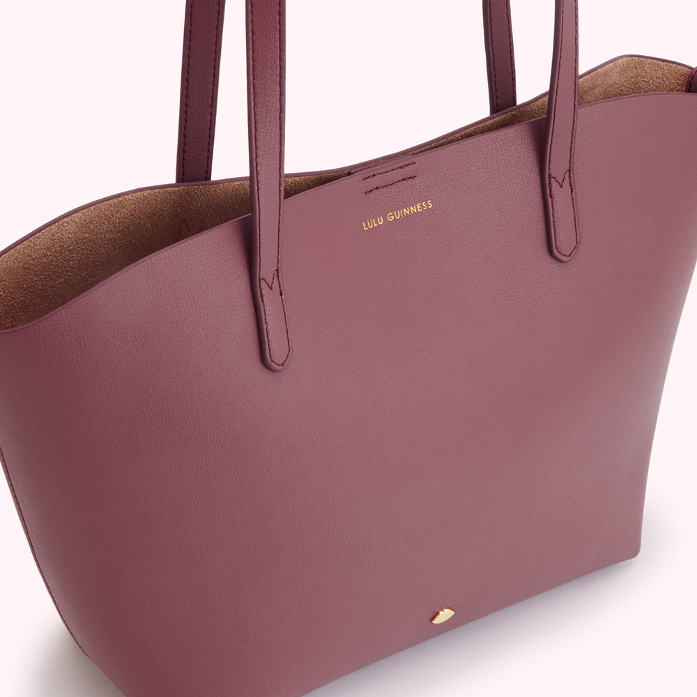 A burgundy Lulu Guinness tote bag with leather handles.
