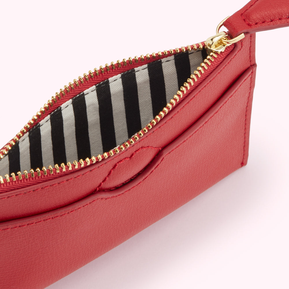 Red leather zip-around coin purse with black and white striped lining.