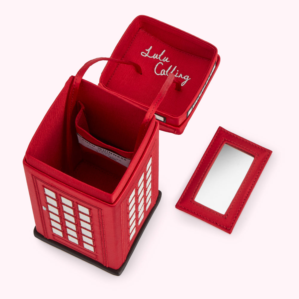Red Lulu Guinness phone box-shaped handbag with a mirror, showing the interior lining and "Lulu Calling" embroidered inside the lid.
