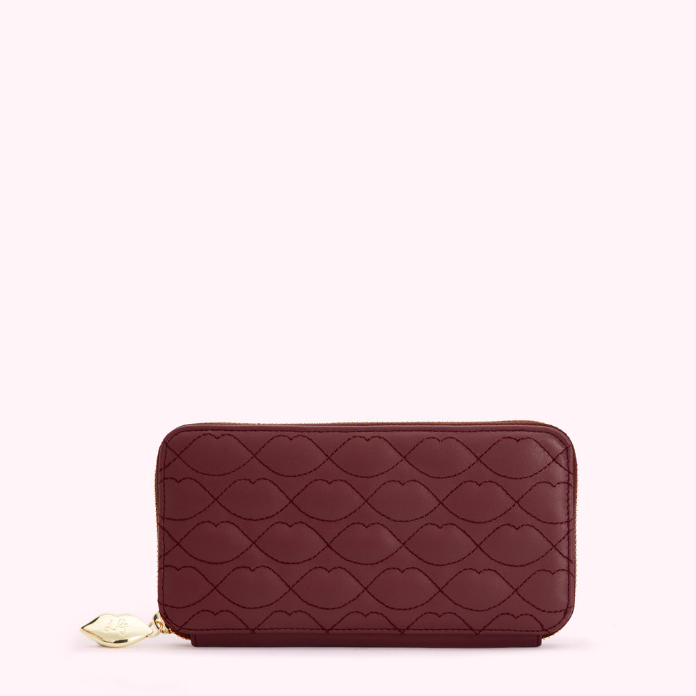 Burgundy quilted zip-around wallet with lip pattern.
