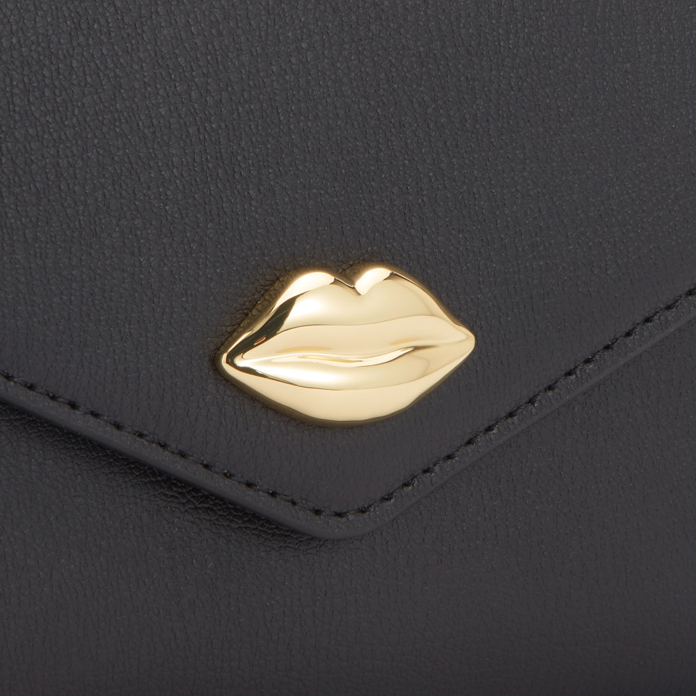 Close-up of a black leather wallet with a gold lip-shaped clasp.
